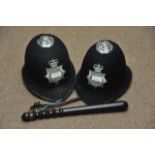 Two Essex police helmets and a wooden truncheon