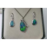 An opal and diamond pendant set in 14k white gold