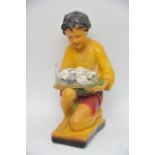 A1930's plaster figure of a kneeling boy holding a