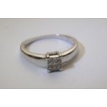 A white gold ring set with princess cut diamonds i