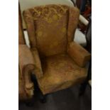 A wing back open armchair on cabriole legs with ba