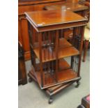 An Edwardian Mahogany revolving bookcase on cabrio