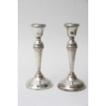 A pair of silver candle sticks with turned columns