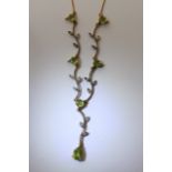 A diamond and peridot necklet in the form of leaves on a branch.