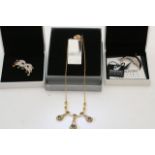 Two boxed Swarovski brooches of a mask and dolphin