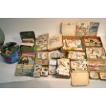 A box containing cigarette cards, tea cards and po