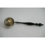 A continental silver straining ladle with turned w