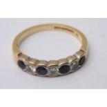 An 18ct gold ring inset with four sapphires and t