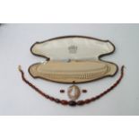 A cameo brooch, simulated pearl necklace and a bak