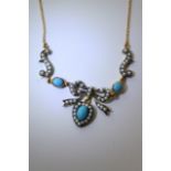 A turquoise and pearl bow necklace on a gold chain.