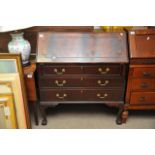 A mahogany bureau raised on ball and claw feet, ap