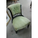 A nursing chair with green upholstered seat and ba