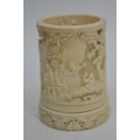 An antique ivory brush pot carved with figures out