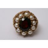 A 9ct gold ring inset with a garnet, surrounded by