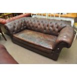 A brown leather button back Chesterfield sofa, app