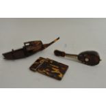 A tortoiseshell card case a miniature mandolin and