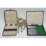 A metal model of a deer and two cased cutlery sets