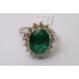 A 14ct white gold, oval emerald and diamond ring,