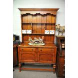 A stained pine dresser fitted with two drawers ove