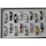 A collection of 16 watches in a display case.