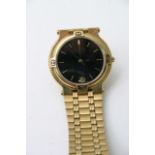 A gold tone Gucci watch with a black dial date ape