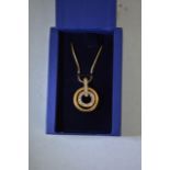 A gold toned Swarovski dual circular pendant, the