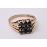 A 9ct gold ring set with a square pattern of blue