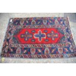 An antique rug in blue, red and cream, approx 112c