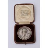 A white metal commemorative medallion, James McDon