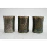 Three heavy silver beakers with engraved decoratio