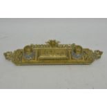 A double brass inkwell decorated with cherubs.