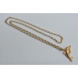 A 9ct gold pendant in the form of a dolphin on a c