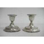 A pair of petite hallmarked silver candlesticks da