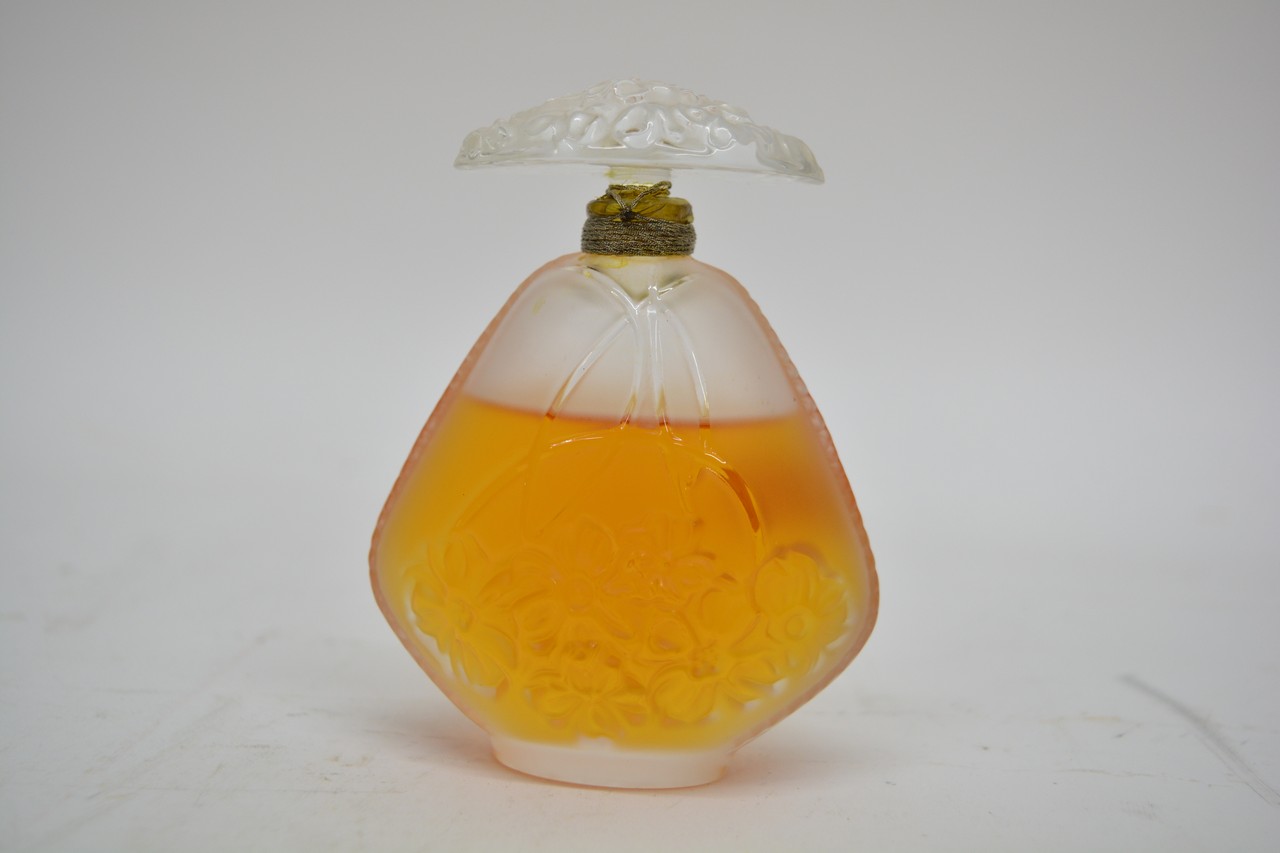 A Lalique perfume bottle decorated with flowers.