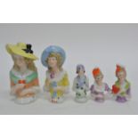 A collection of ten ceramic pin dolls of various d