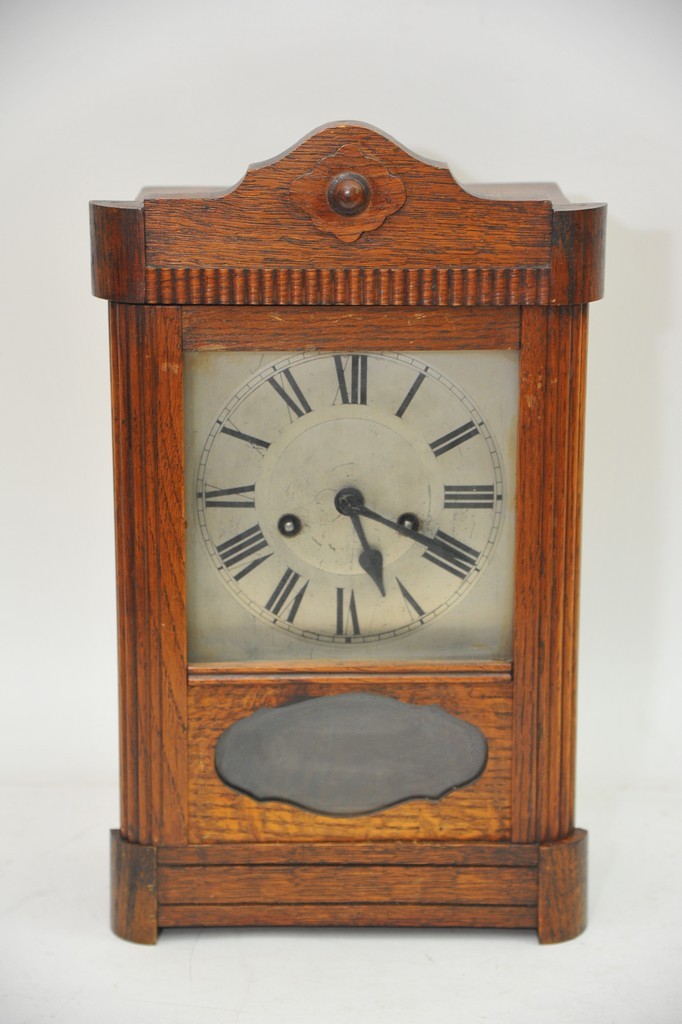 An oak cased 8 day clock with silvered dial and Roman numerals, approx height 38.5cm.