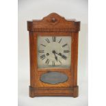 An oak cased 8 day clock with silvered dial and Roman numerals, approx height 38.5cm.