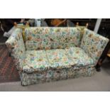 A Parker Knoll knole sofa recovered with a naturalistic fabric featuring birds, flowers, foliage and
