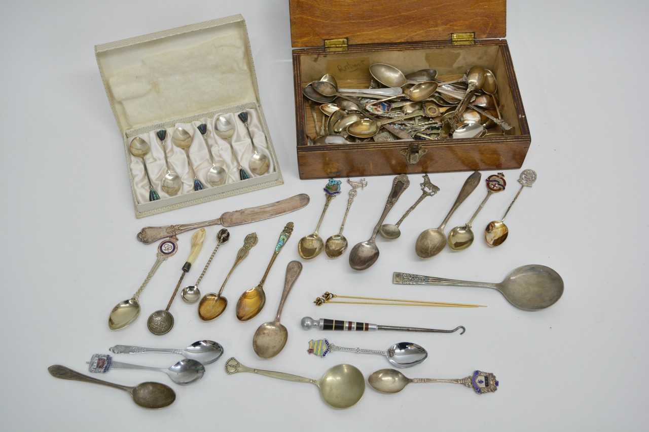 A collection of silver and plated spoons in wooden