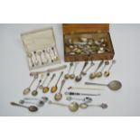 A collection of silver and plated spoons in wooden