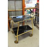 A modern design two tier trolley in smoked black glass.