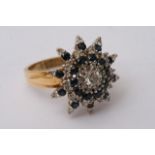 An 18ct yellow gold ring set with a large sapphire and diamond cluster. Approximately size V