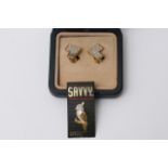 A pair of Swarovski earrings and a Swarovski pin b