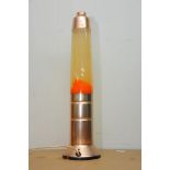 A rose gold coloured lava lamp with luminous orange coloured lava