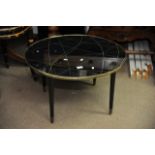 A 1960s retro look black, glass and brass circular coffee table, the table top design having yellow,