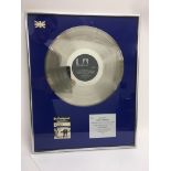 A framed and glazed silver disc for the Dr Feelgoo
