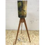 A teak tripod floor lamp with matched mottled fibr