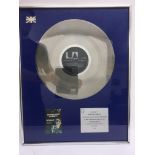 A framed and glazed silver disc for the Dr Feelgoo