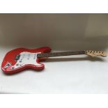A Fender Stratocaster style guitar in fiesta red w