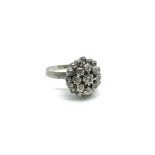 An 18ct white gold flower head ring inset with dia